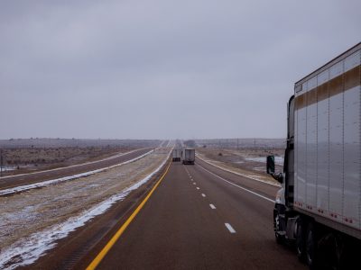 Cargo truck on Arizona desert highway seen on winter snow covers the highway